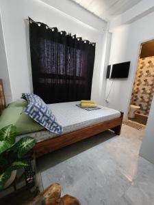 a bed in a room with a black curtain at ASHBURN'S TRANSIENT Bauang LA UNION- SELF CHECK-IN, SELF SERVICE in Bauang