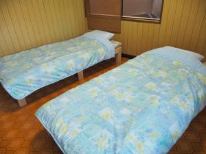 Postel nebo postele na pokoji v ubytování ゲストハウス黒島