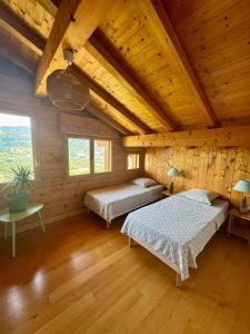 Un dormitorio con dos camas en una cabaña de madera. en Chalet les vergers, en Sallanches