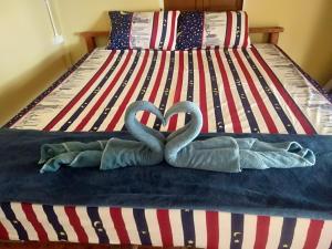 zwei Schwäne machen ein Herz auf einem Bett in der Unterkunft Longbeach Bungalow Kohmook in Ko Mook