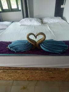 Zwei Schlangen bilden ein Herz auf einem Bett in der Unterkunft Longbeach Bungalow Kohmook in Ko Mook