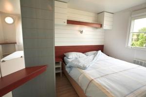 een kleine slaapkamer met een bed en een raam bij Les Cottages du Limonay in Saint-Méloir-des-Ondes