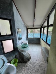 a bathroom with a sink and a toilet and windows at Smile Bungalow Bottle Beach in Bottle Beach
