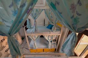 a bunk bed in a room with curtains at Whereabout Hostel Udaipur in Udaipur