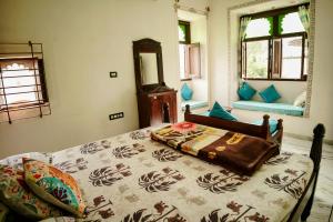 a bedroom with a bed and a mirror at Whereabout Hostel Udaipur in Udaipur