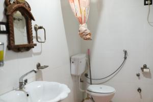 a bathroom with a toilet and a sink and a mirror at Whereabout Hostel Udaipur in Udaipur