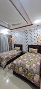 two beds sitting next to each other in a bedroom at Sapphire Residency in Niāziān