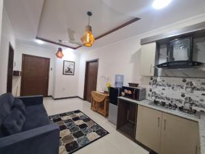 a kitchen and living room with a couch and a tv at Sapphire Residency in Niāziān +3 photos