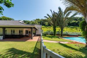 a house with a pool and a fence at 10 Malibu, Beverly Hills Estate in Ballito