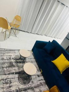 a living room with a blue couch and two tables at KT Comfort in Midrand +10 photos