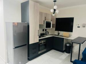 a kitchen with a stainless steel refrigerator and a table at KT Comfort in Midrand
