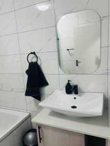 a white bathroom with a sink and a mirror at KT Comfort in Midrand +10 photos