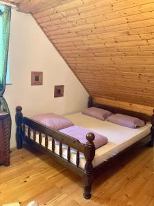a bed in a room with a wooden ceiling at Papa Franks House in Ptuj +15 photos