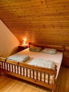 a bed in a room with a wooden ceiling at Papa Franks House in Ptuj