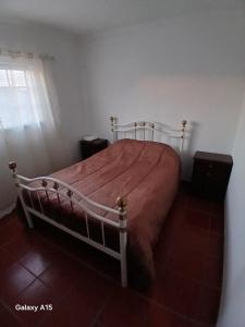 a bedroom with a large bed with a red comforter at Casa da Padaria in Caldas da Rainha