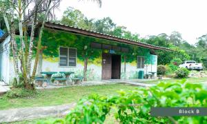 un edificio con tavolo e panche di fronte ad esso di Betong He Ping Village หมู่บ้านจุฬาภรณ์พัฒนา10 a Betong