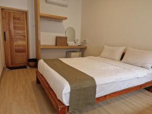 a bedroom with a large bed with white sheets at Samed Thanee in Ko Samed