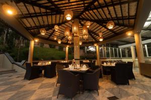 a restaurant with tables and chairs under a wooden ceiling at Paragon Hotel & Resort in Sreemangal