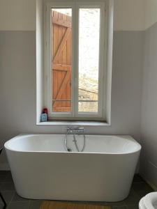 ペリアック・ド・メールにあるLa grande maison roseの窓のある浴室の白い浴槽 +32枚の写真