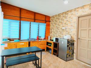 a kitchen with a table and a refrigerator in it at PULANG RESORT in Setiu