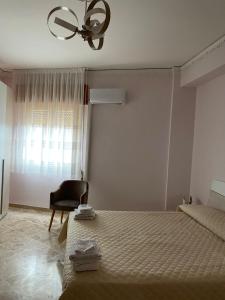 a bedroom with a bed and a chair and a window at Casa vacanze anto antonella in Bagheria