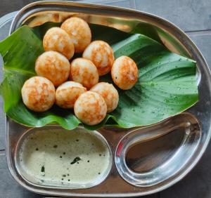 a tray of food with balls of food on leaves at Vinayaka Homestay Hampi in Hampi +65 photos
