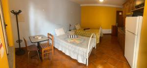 a small room with a table and a kitchen with a refrigerator at Vale do Gavim, Rua das Seixas in Trancoso