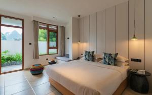 a bedroom with a large bed and a large window at 悦田生活酒店 in Gaotian