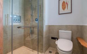 a bathroom with a toilet and a glass shower at 悦田生活酒店 in Gaotian