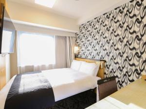 a hotel room with a bed and a window at APA Hotel Ikebukuro Eki Kitaguchi in Tokyo