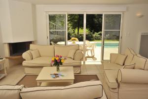 sala de estar con sofás y mesa en Lagrange Vacances - Royal Green en Pont-de-Larn