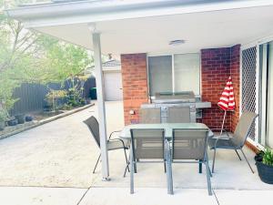 a patio with a table and chairs and a grill at Welcome to Sunny Sanctuary in Carrum Downs