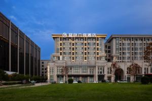 郑州新郑国际机场BlueVisual Hotel Zhengzhou Airport的顶部有标志的建筑物