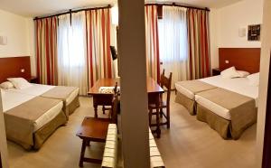 pokój hotelowy z dwoma łóżkami i stołem w obiekcie Hotel Torres Touriño w mieście Sanxenxo