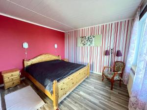 una camera con letto in legno e parete rossa di Holiday house by riverside with sauna and hottub a Moholm Altre 14 foto