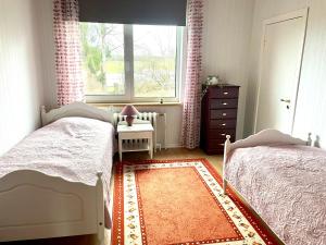 una piccola camera da letto con due letti e una finestra di Holiday house by riverside with sauna and hottub a Moholm
