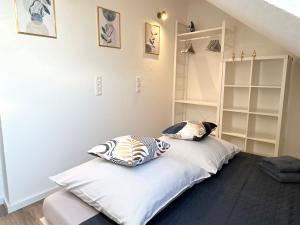 a bed with two pillows on it in a room at LGH-Moderne, ruhige Wohnung, Nähe zum Flughafen und Autobahn, 24h-self-check-in, vollausgestattet, DisneyPlus, Waschmaschine in Langenhagen