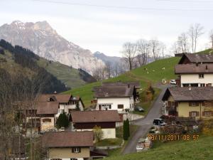 ein Dorf mit Häusern und einer Straße in den Bergen in der Unterkunft Ferienstudio in Unterschächen in Unterschächen