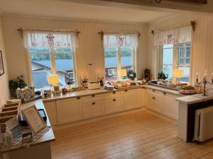 a large kitchen with white cabinets and windows at Vasacenter B&B in Transtrand