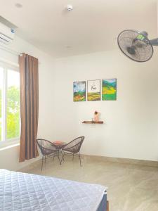 a bedroom with two chairs and a table and a window at Tamcoc Motel in Văn Lâm