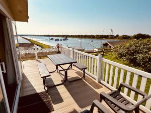 a wooden deck with a table and chairs on a balcony at Sandpiper Port Haverigg Marina in Millom