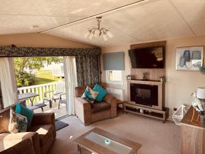 a living room with a couch and a television and a table at Sandpiper Port Haverigg Marina in Millom