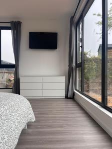 a bedroom with a tv and large windows at Deerpark 3 bed semi Sleeps 6 & Optional extra outdoor sauna in Cashel