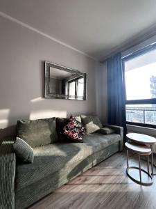 ヴロツワフにあるApartament Podwale Odra Tower Rynek 15 floorのソファと鏡のあるリビングルーム