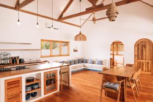 a kitchen and living room with a table and a couch at Kubu Pantai - Bela Sulu Villas in Katiet