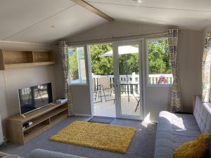 a living room with a couch and a television at 49 Solent Breeze in Porchfield