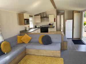 a living room with a couch and a kitchen at 49 Solent Breeze in Porchfield