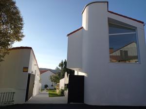 a white building with a large window on the side of it at LAR JARDÍN - Casas independientes con jardín y parking privado in Santiago de Compostela