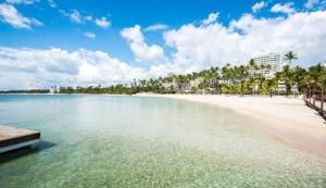 a view of a beach with a boat in the water at Dre Broeders Apartments Juan Dolio in Juan Dolio