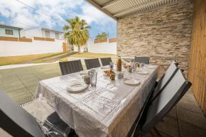 a table with a white table cloth on a patio at Villa Noé - Famille, détente et Jacuzzi - Wiskeys in Commune Bègue
